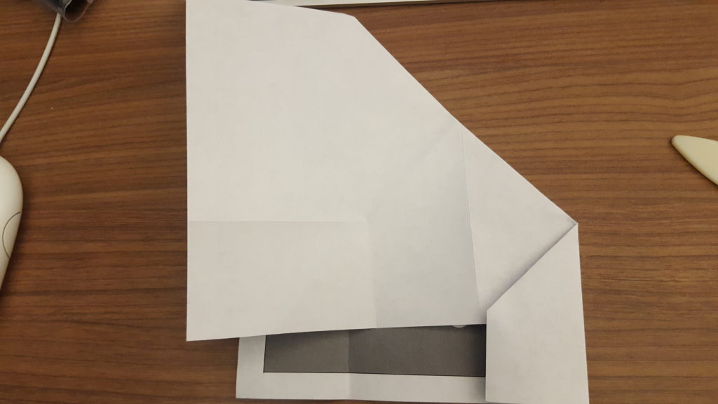 A piece of paper folded in half with a corner tucked over.