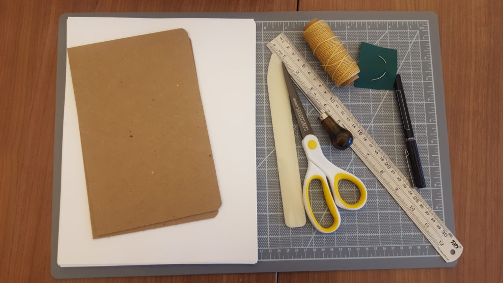 A set of supplies for making a coptic stitch book.