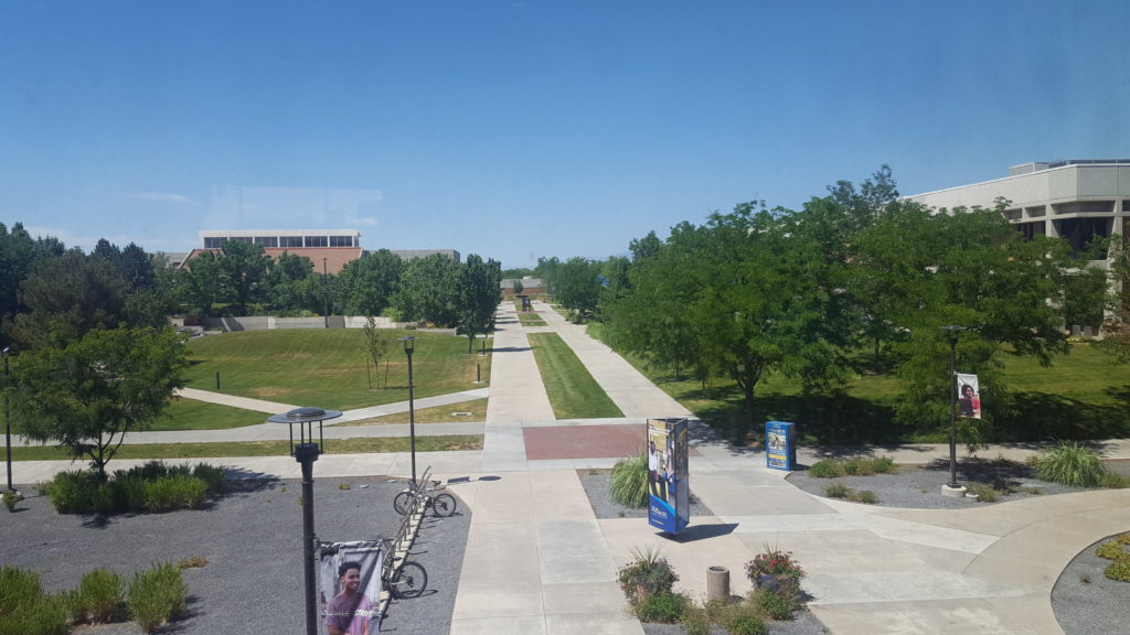 An aerial view of the Salt Lake Community college campus, showing a t-shaped walkways with bicycles parked in one corner, and trees lining the walkways.