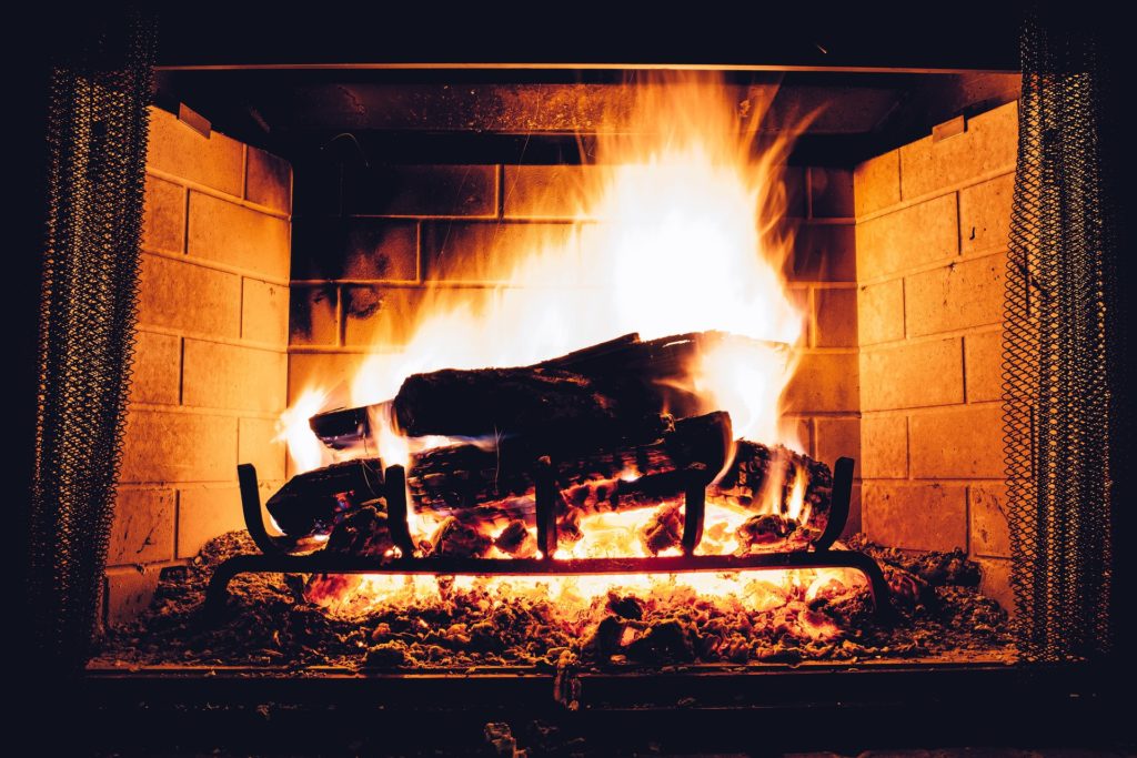 A fireplace with logs burning.