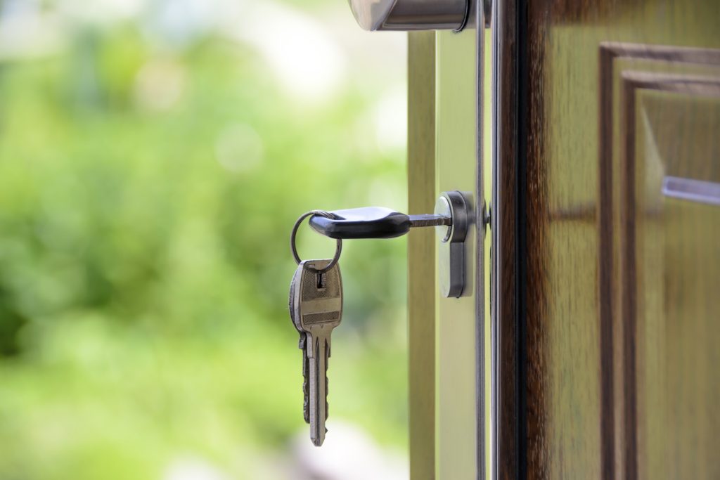 A key hangs from the lock in a doorway.