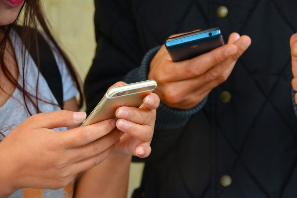 Two people hold smartphones in their hands.